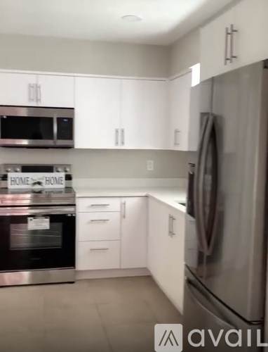 A kitchen with white cabinets and stainless steel appliances.