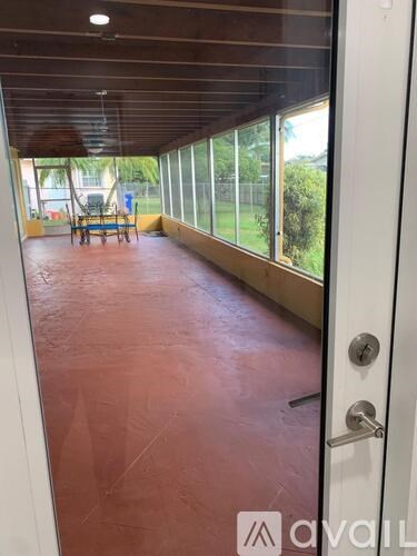 A room with a red floor and a glass door leading to a patio.