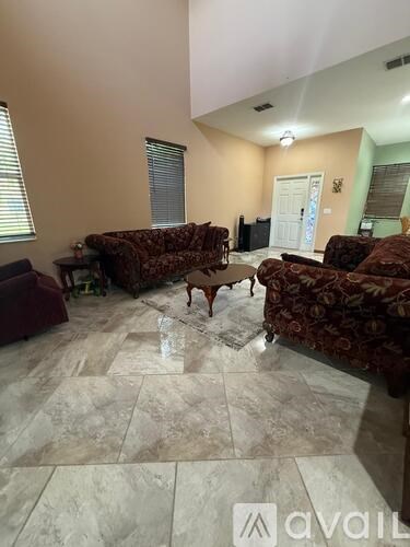 A living room with a brown patterned sofa and a wooden coffee table.