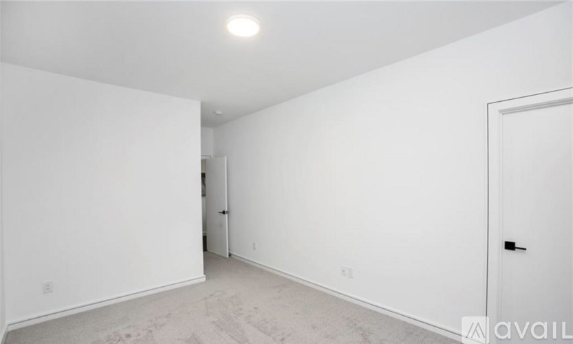 A spacious room with a door on the right and a door on the left.