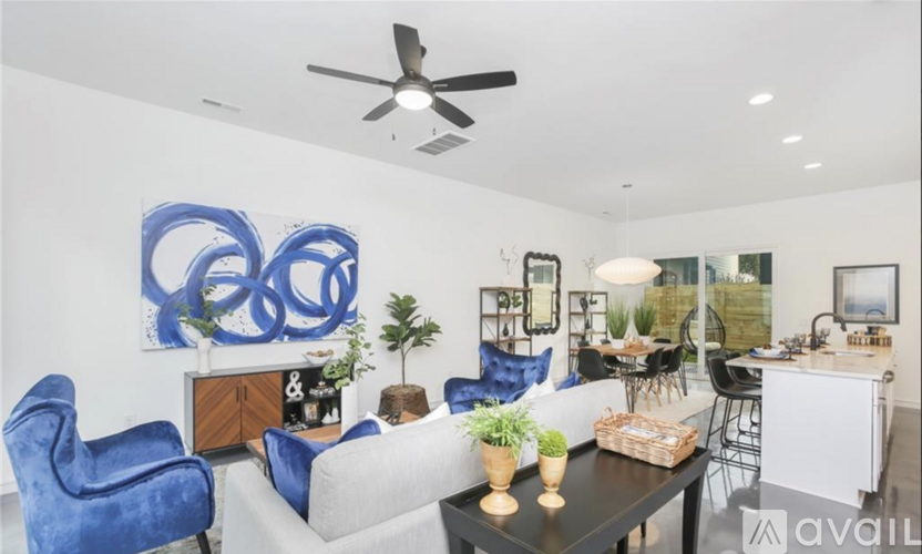 A living room with a blue chair and a large blue painting on the wall.