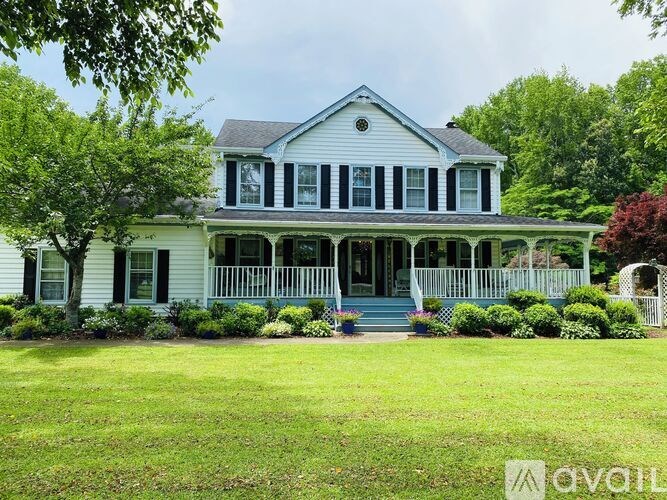 A white house with a blue roof and a porch.