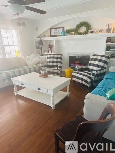 A living room with a white couch, a coffee table, and a fireplace.