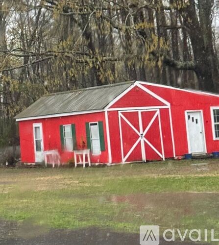A red barn with white trim and a white door.