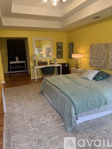 A bedroom with a bed, nightstand, and lamp.