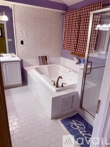 A white bathtub with a brown checkered curtain in a bathroom.