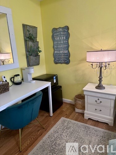 A room with a desk, chair, and lamp.