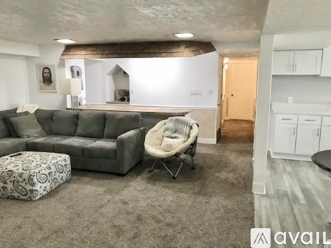 A living room with a grey sofa and a white chair.