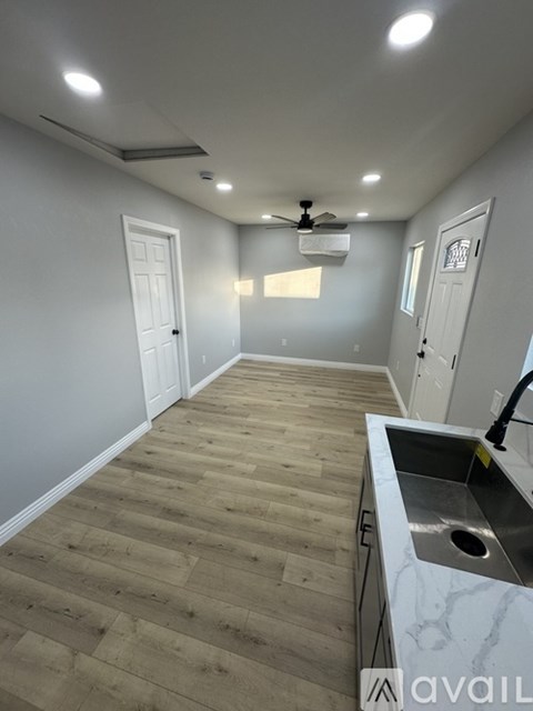 A kitchen with a sink and a ceiling fan.