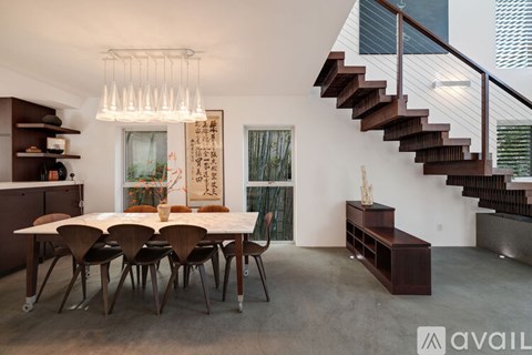 A modern dining room with a wooden table and chairs.