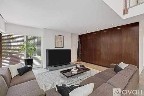 A living room with a grey sofa and a television.