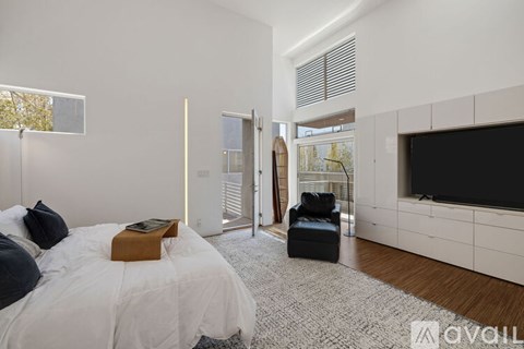 A bedroom with a large bed and a television in the corner.
