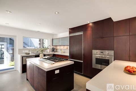 A modern kitchen with dark wood cabinets and a white island.