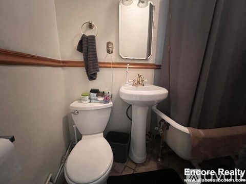 A bathroom with a toilet, sink, and bathtub.