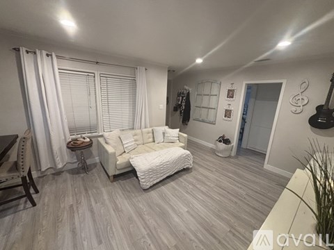 A living room with a white couch and a wooden floor.