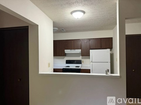 A kitchen with brown cabinets and white appliances.