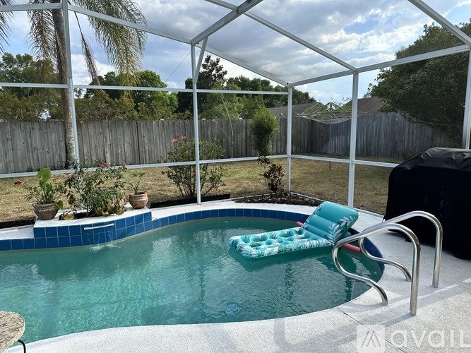 A pool with a chair and a table in the foreground.