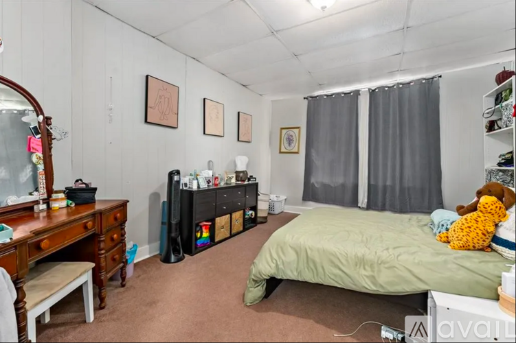 A bedroom with a bed, dresser, and a mirror.