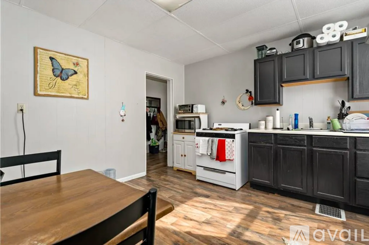 A kitchen with a wooden table and a butterfly picture on the wall.