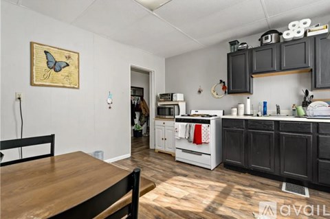 A kitchen with a wooden table and a butterfly picture on the wall.