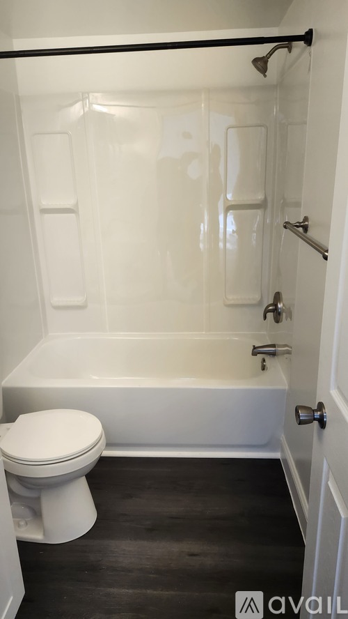 A white toilet sits next to a bathtub in a bathroom.