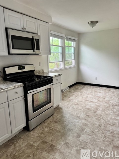 A kitchen with white cabinets and a black stove top oven.