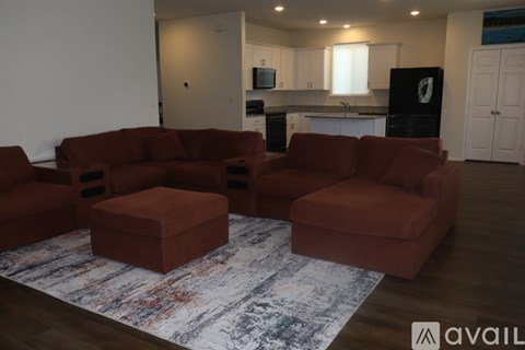 A living room with a red couch and ottoman.
