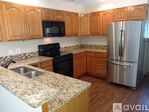 A kitchen with wooden cabinets and a granite countertop.