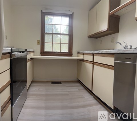 A kitchen with a window, sink, and appliances.