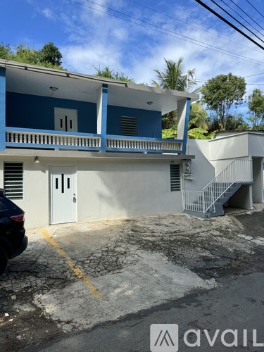 A blue and white building with a car parked in front.