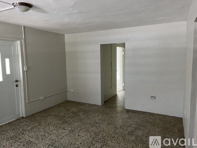 A room with a speckled floor and a ceiling fan.