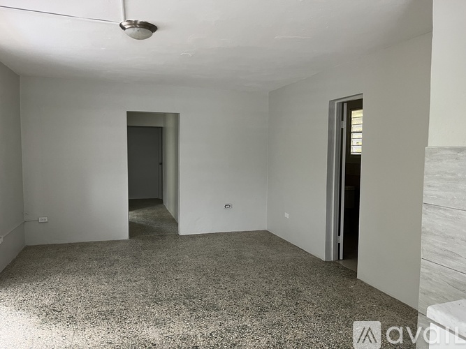 A room with a grey carpet and white walls.