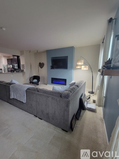 A living room with a grey couch and a television on a blue cabinet.