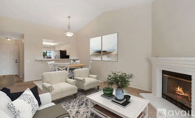 A living room with a fireplace and a painting on the wall.