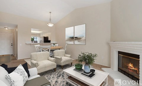 A living room with a fireplace and a painting on the wall.