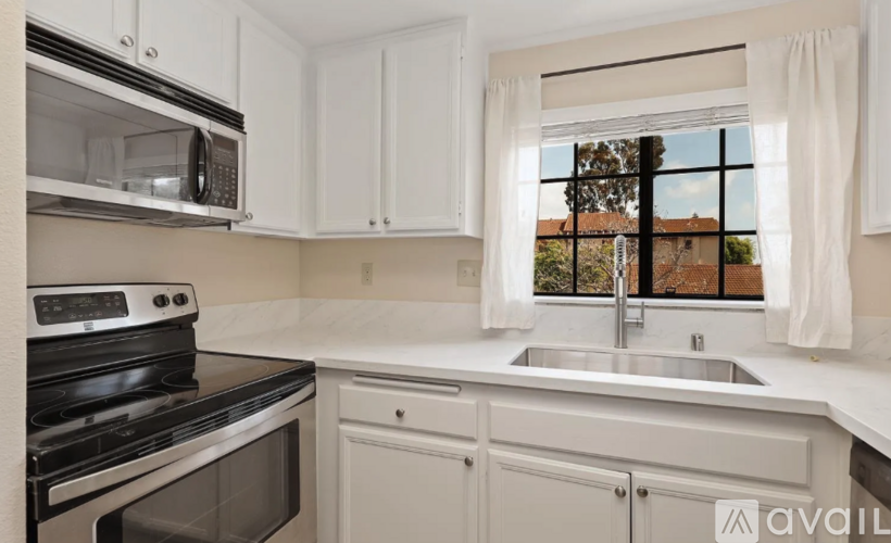 A kitchen with white cabinets and a stainless steel oven.