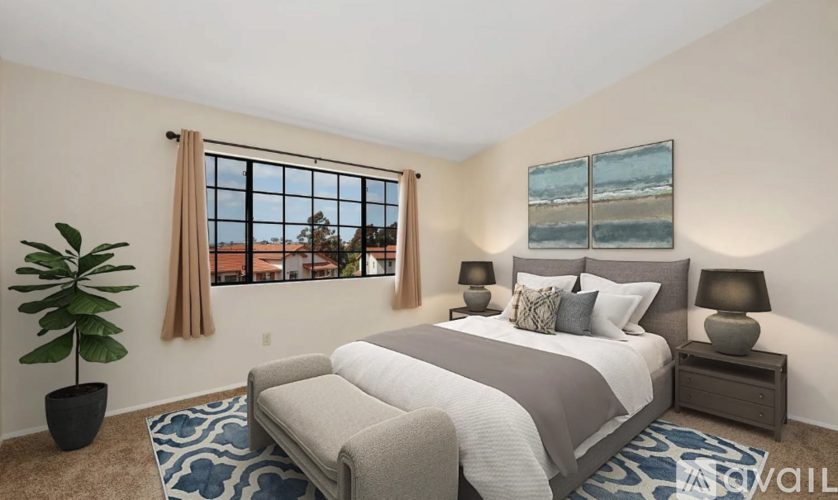 A bedroom with a large bed and a view of the outside through the window.