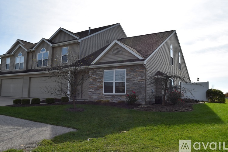 A house with a grey roof and a white garage door.