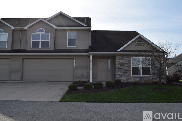 A house with a grey roof and a stone wall.