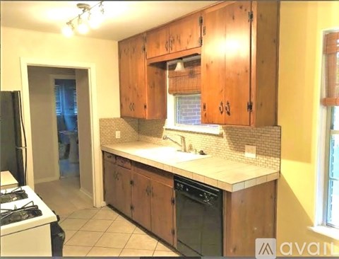A kitchen with wooden cabinets and a black oven.