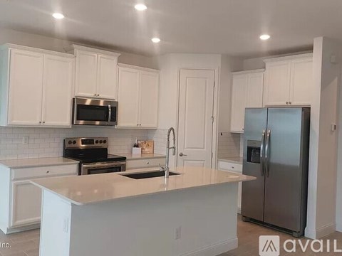A kitchen with white cabinets and a stainless steel refrigerator.