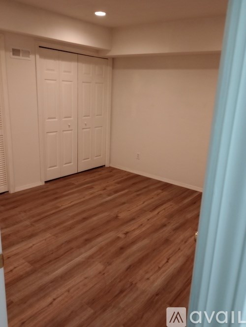 A room with wooden flooring and white walls.