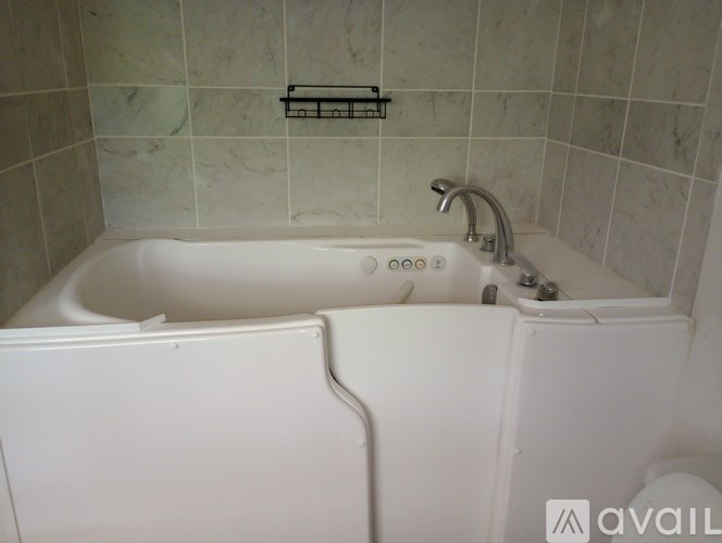 A white bathtub with a silver faucet and a white towel hanging on the side.