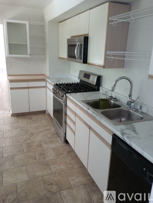 A kitchen with a black dishwasher and a black stove top.