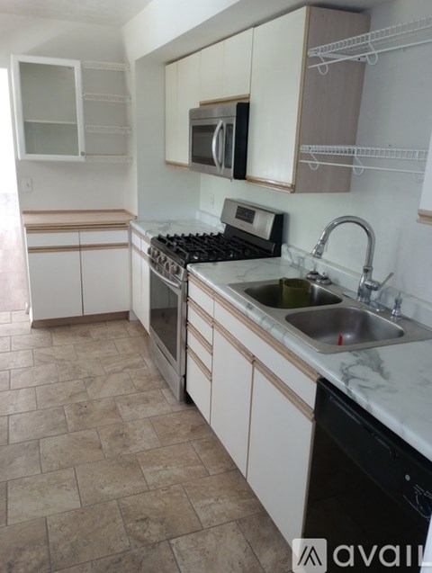 A kitchen with a black dishwasher and a black stove top.