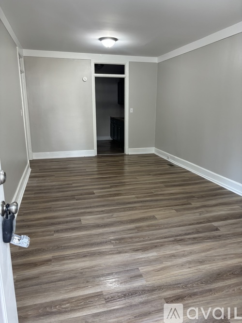 A room with wooden flooring and a white door.