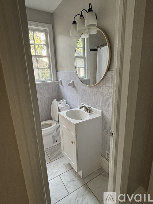 A bathroom with a sink, toilet and a mirror.