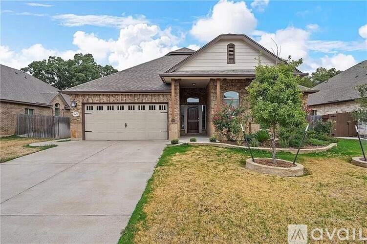 A house with a garage and a driveway in front of it.
