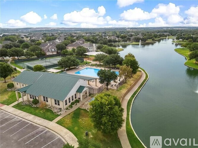 A bird's eye view of a house with a swimming pool and a lake in the background.