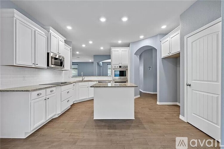 A kitchen with white cabinets and a central island.